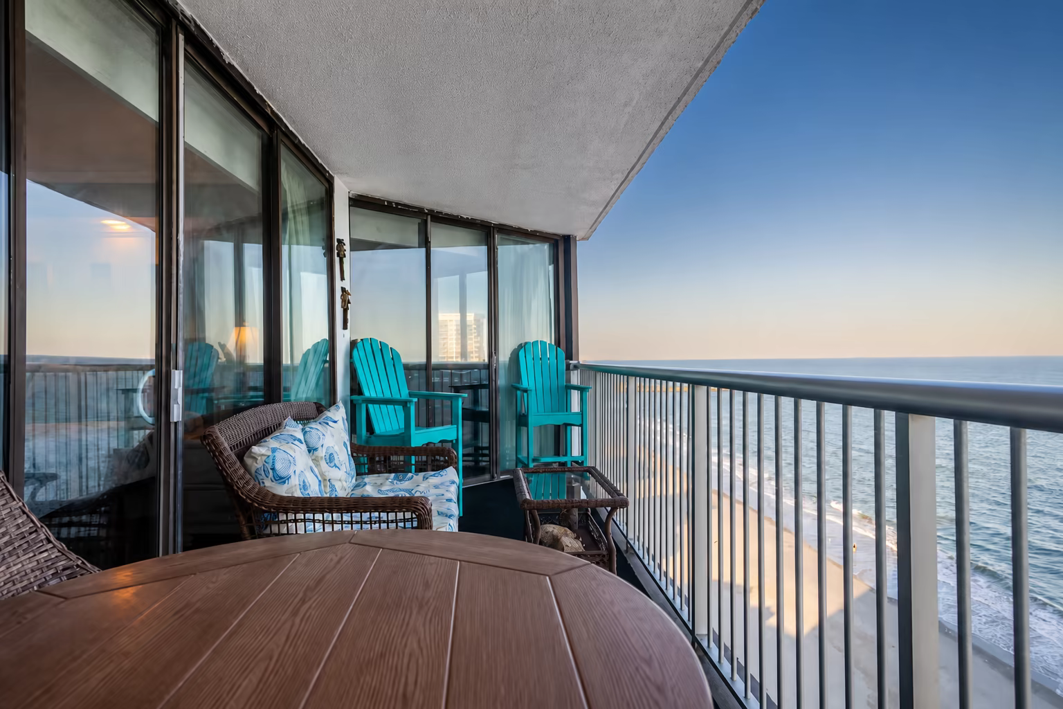 Private penthouse balcony with table and chairs overlooking the pools and ocean